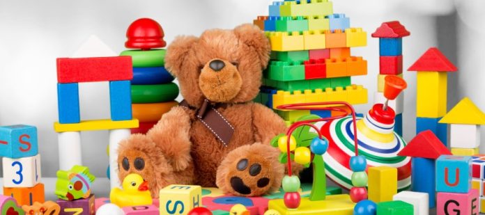 A pile of various toys, from teddy bears and rubber ducks to building blocks and blocks with letters on them.