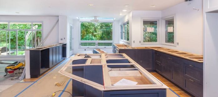 A large kitchen space with balsa wood templates on top of the cabinets to determine the dimensions for new countertops.